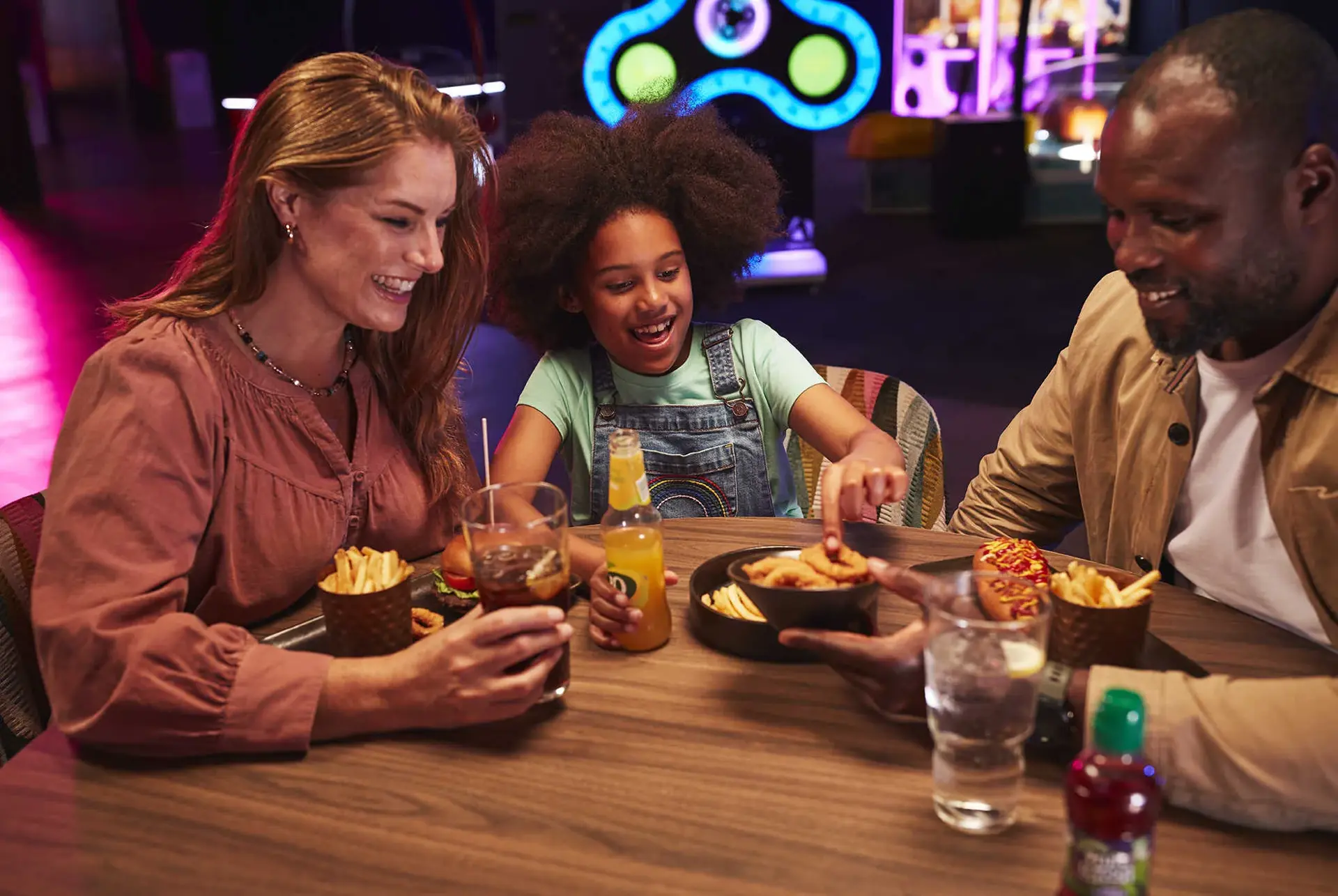 A happy family gathered around a table, enjoying a meal together at Hollywood Bowl
