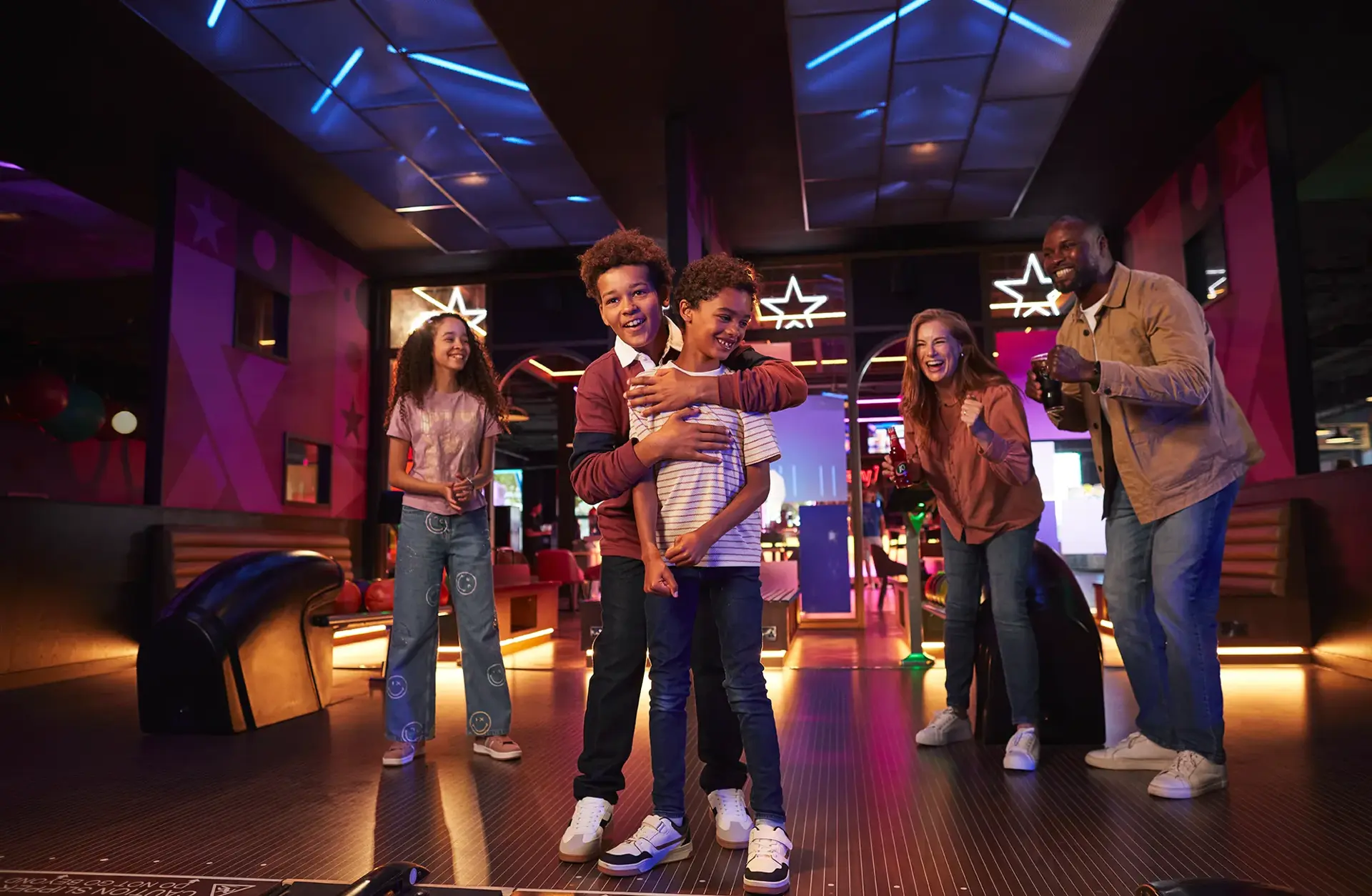 A joyful family enjoys bowling together, laughing and cheering at Hollywood Bowl
