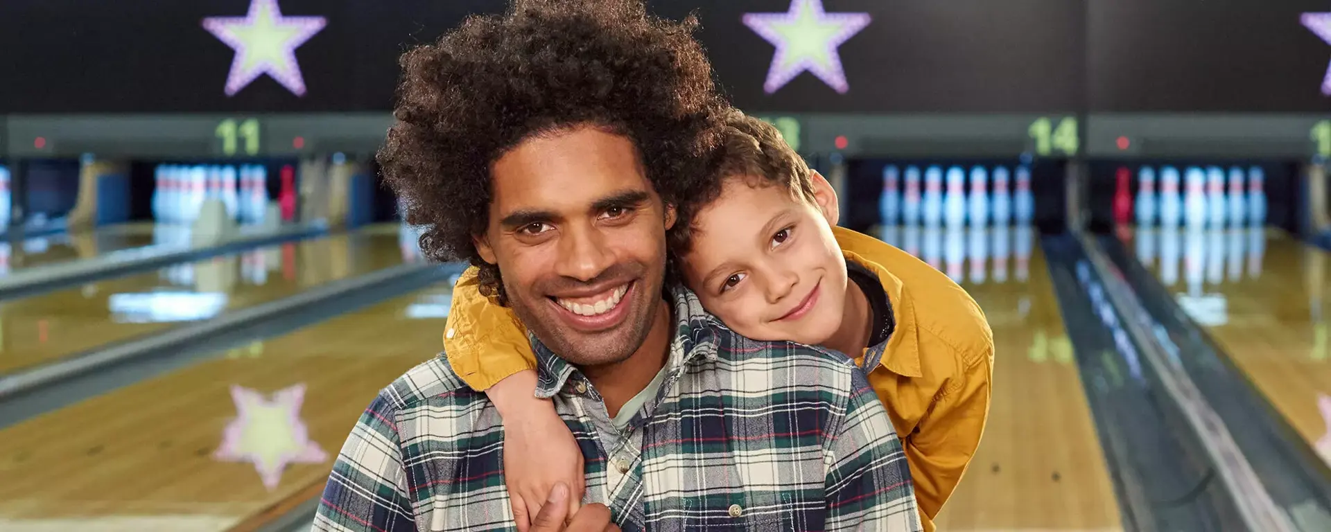Dad and son holding hands on lane together