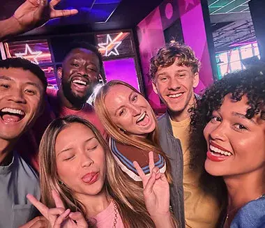 A group of friends smiling and posing together for a photo inside Hollywood Bowl.