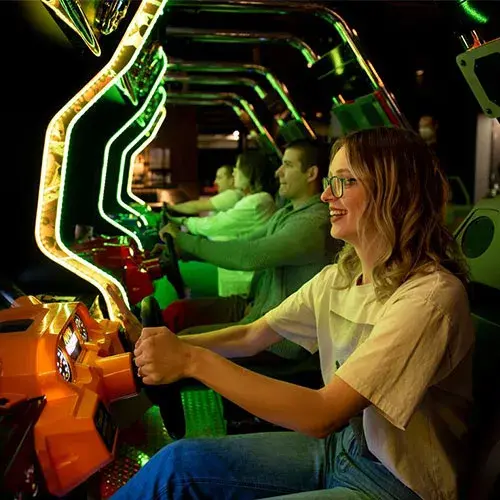 A girl having fun on a driving game in the arcade at Stoked in Saskatoon