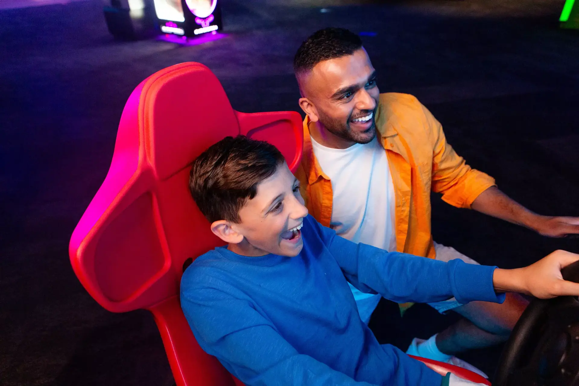 A father and son playing on an arcade machine at Hollywood Bowl