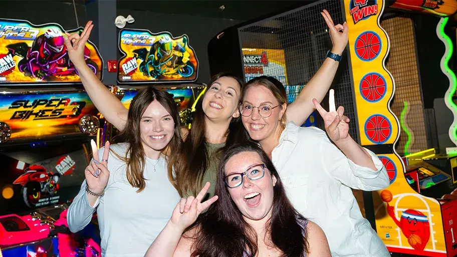Young adults playing on arcade machines at Splitsville Bowl Creekside