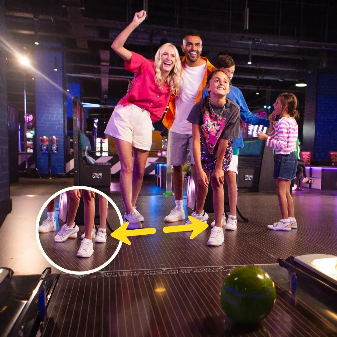 Family wearing own shoes bowling