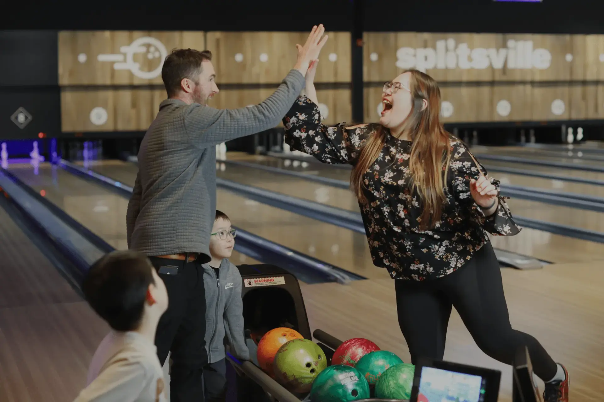 A couple celebrating a strike at Splitsville Bowl
