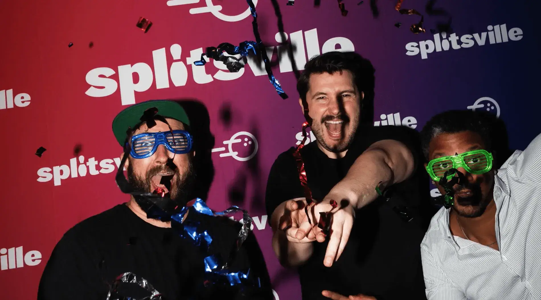 Three smiling men wearing glasses are playfully throwing confetti into the air, enjoying New Years Eve at Splitsville Bowl