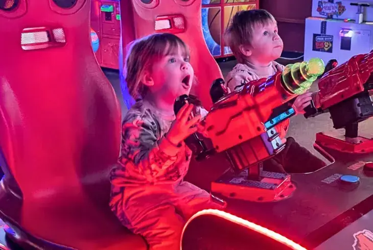 Two toddlers playing in Splitsville's arcade
