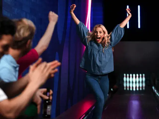 A girl celebrating a strike at a Splitsville Bowl centre