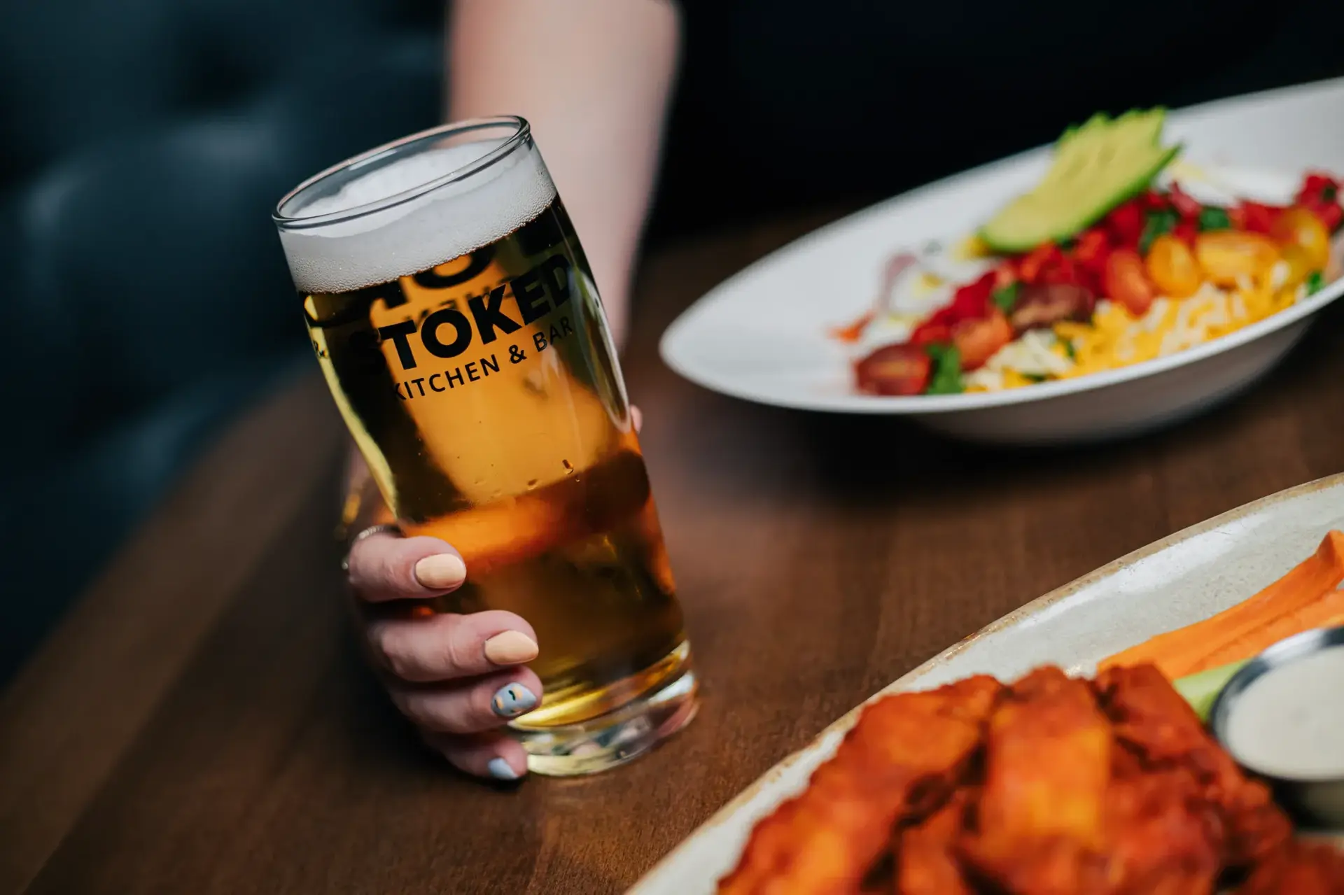 A pint of beer and food at Stoked Kitchen and Bar