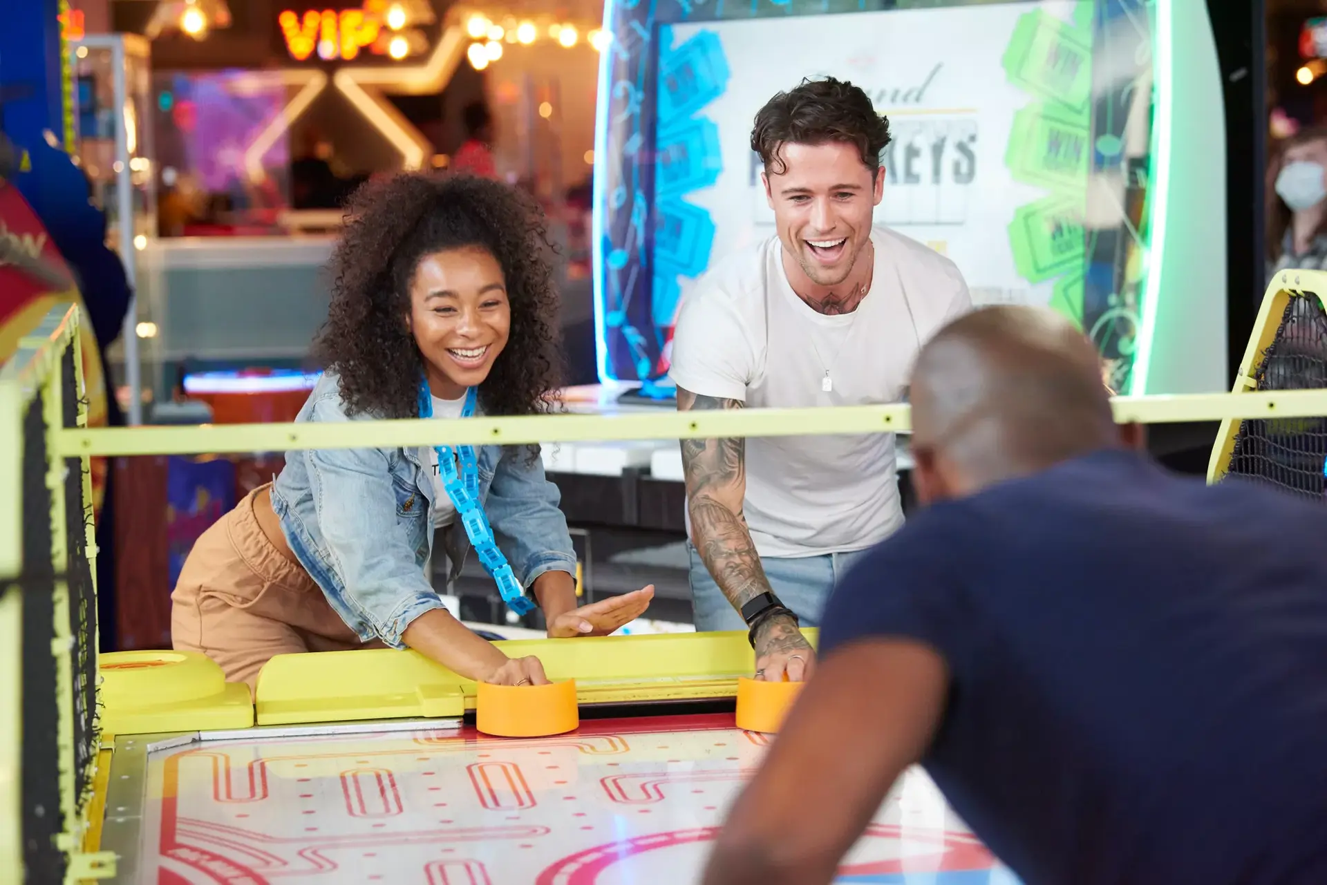 Young adults playing a game in a Hollywood Bowl arcade