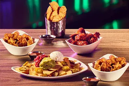 Four plates of delicious food and refreshing drinks, perfect for a gathering or celebration.