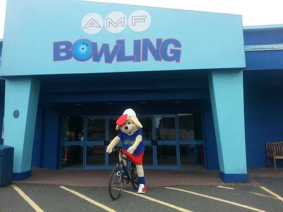 Hollywood Bowl mascot called Bumper riding a bike outside an AMF Bowling centre in Stirling